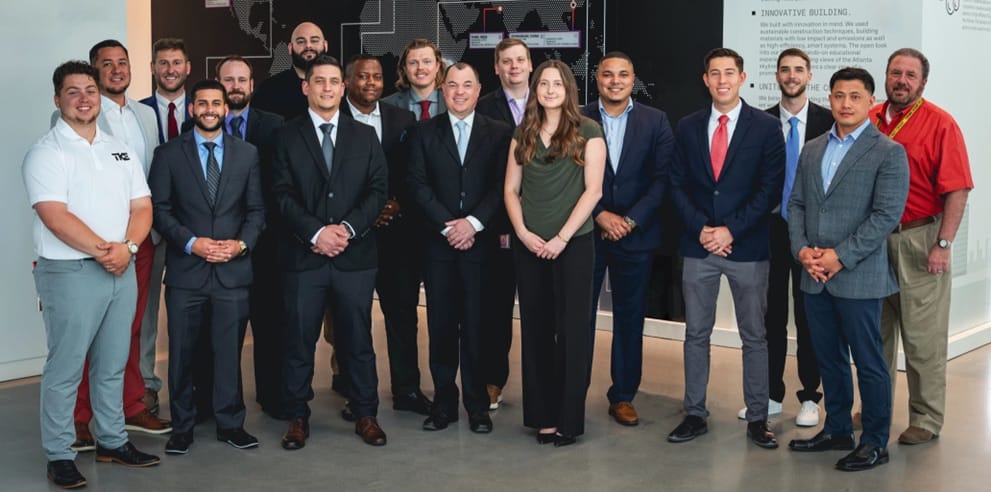 A group of STEP participants in business attire pose together in a TKE office.
